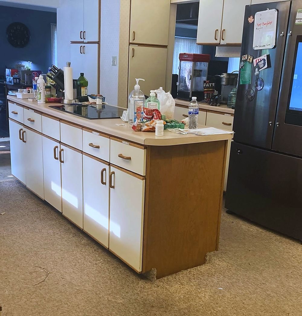 Kitchen before — worn carpet running right up to the cabinets