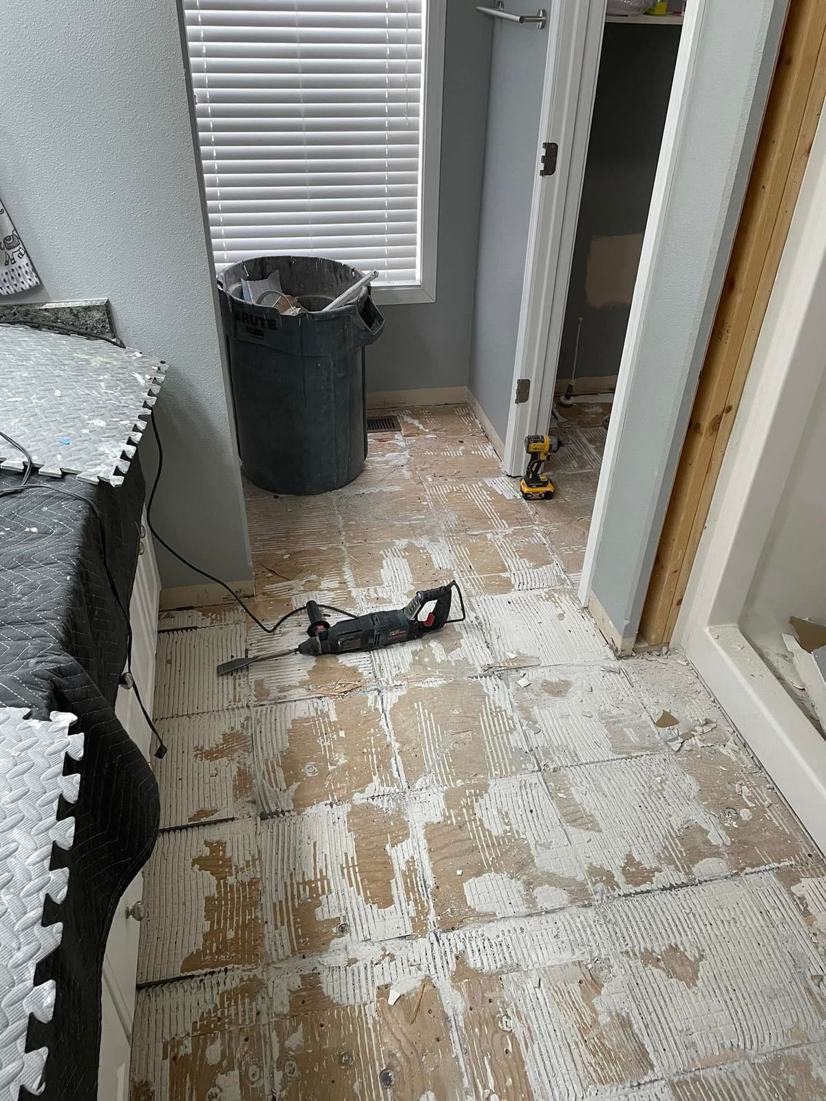 A floor scraped back to clean subfloor before the new tile goes down