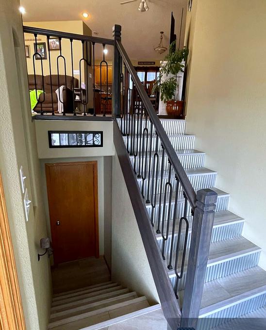 Tiled stair treads with fluted risers and an iron railing